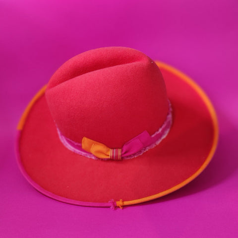 Lina Stein Millinery workshops Red hat with a colorful ribbon on a pink background