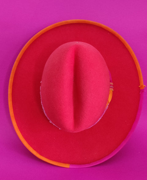 Lina Stein Millinery Red cowboy hat with orange band on a pink background